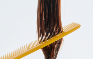 Hair being carefully combed after scalp treatment