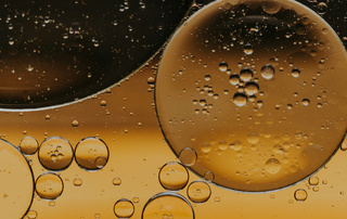 Close-up of Polytar shampoo, thick dark brown liquid with glossy texture, shown outside the bottle for a scientific product detail view